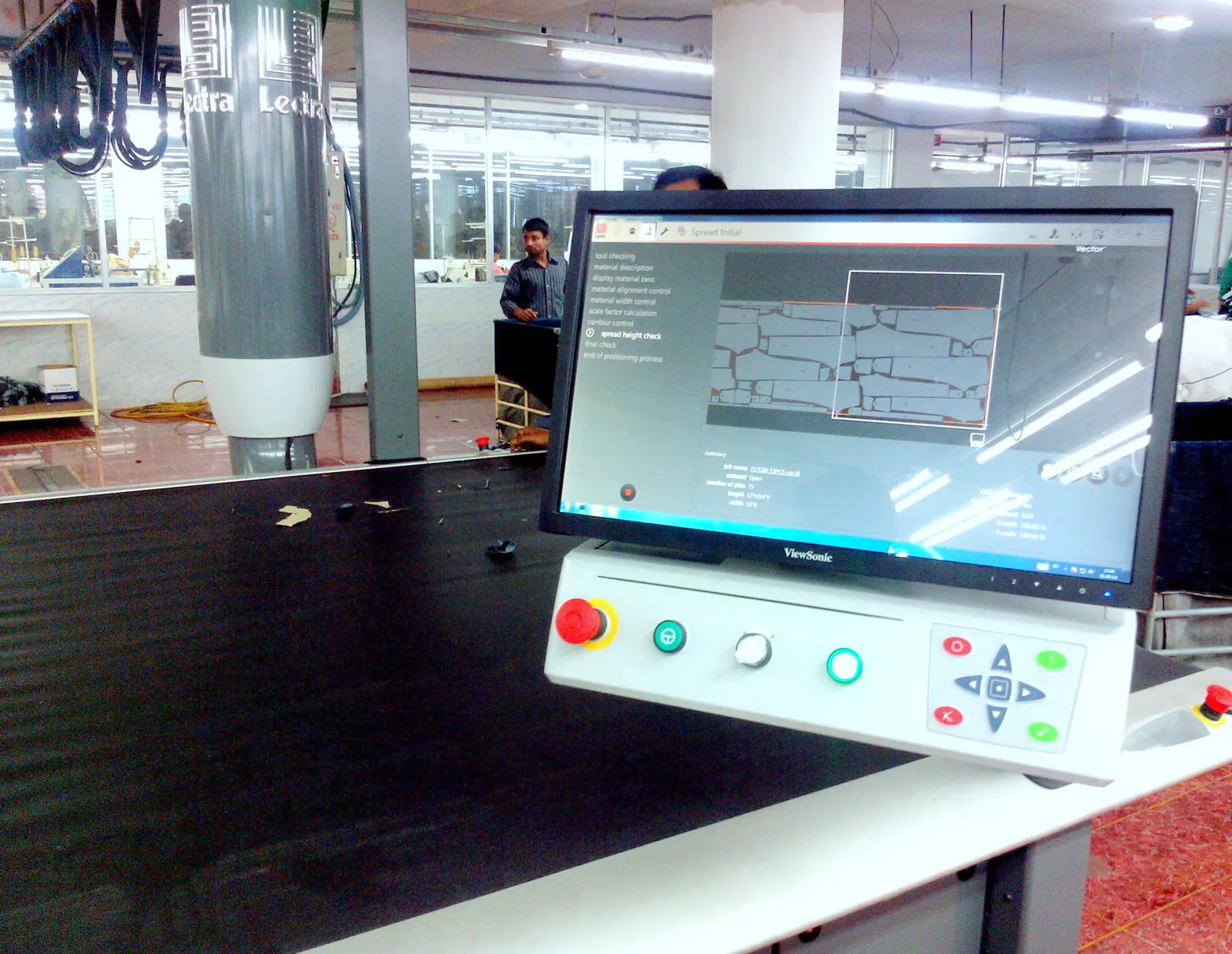 Automatic fabric cutting machine with its control screen in a denim cutting room