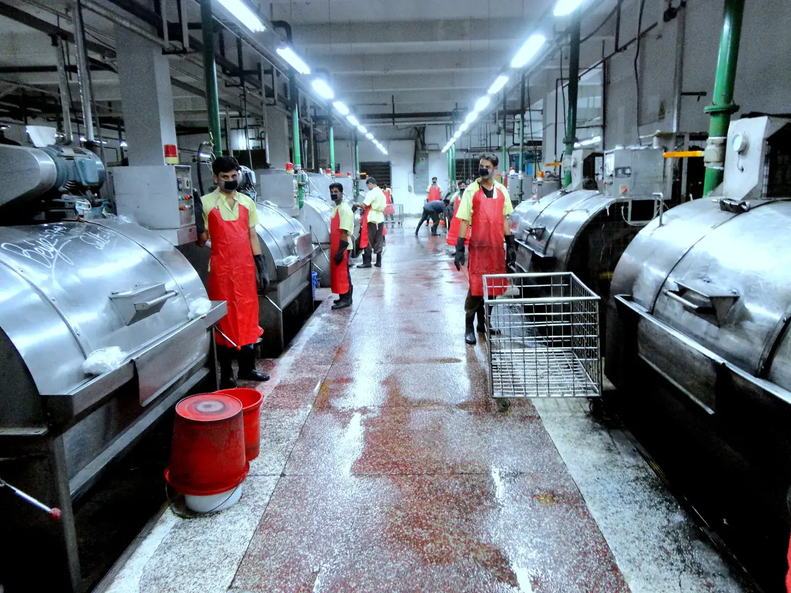 Row of industrial washing machines in a denim garment washing plant