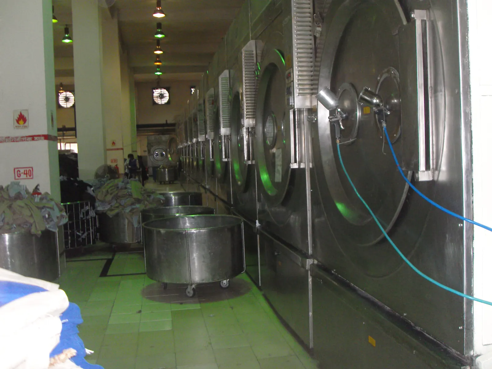 Industrial garment washing machines lined up in a washing factory