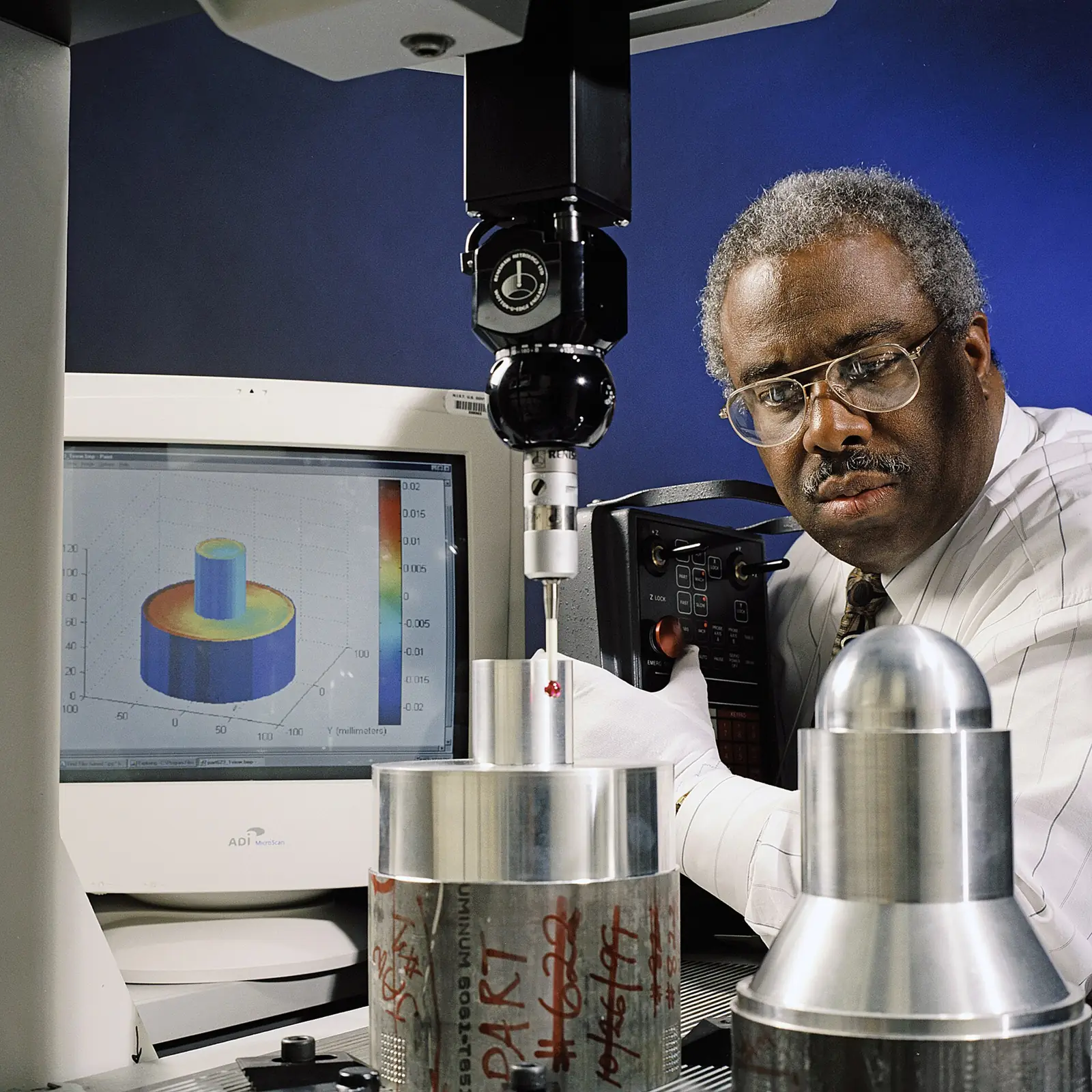 Engineer operating a coordinate measuring machine on a machined part