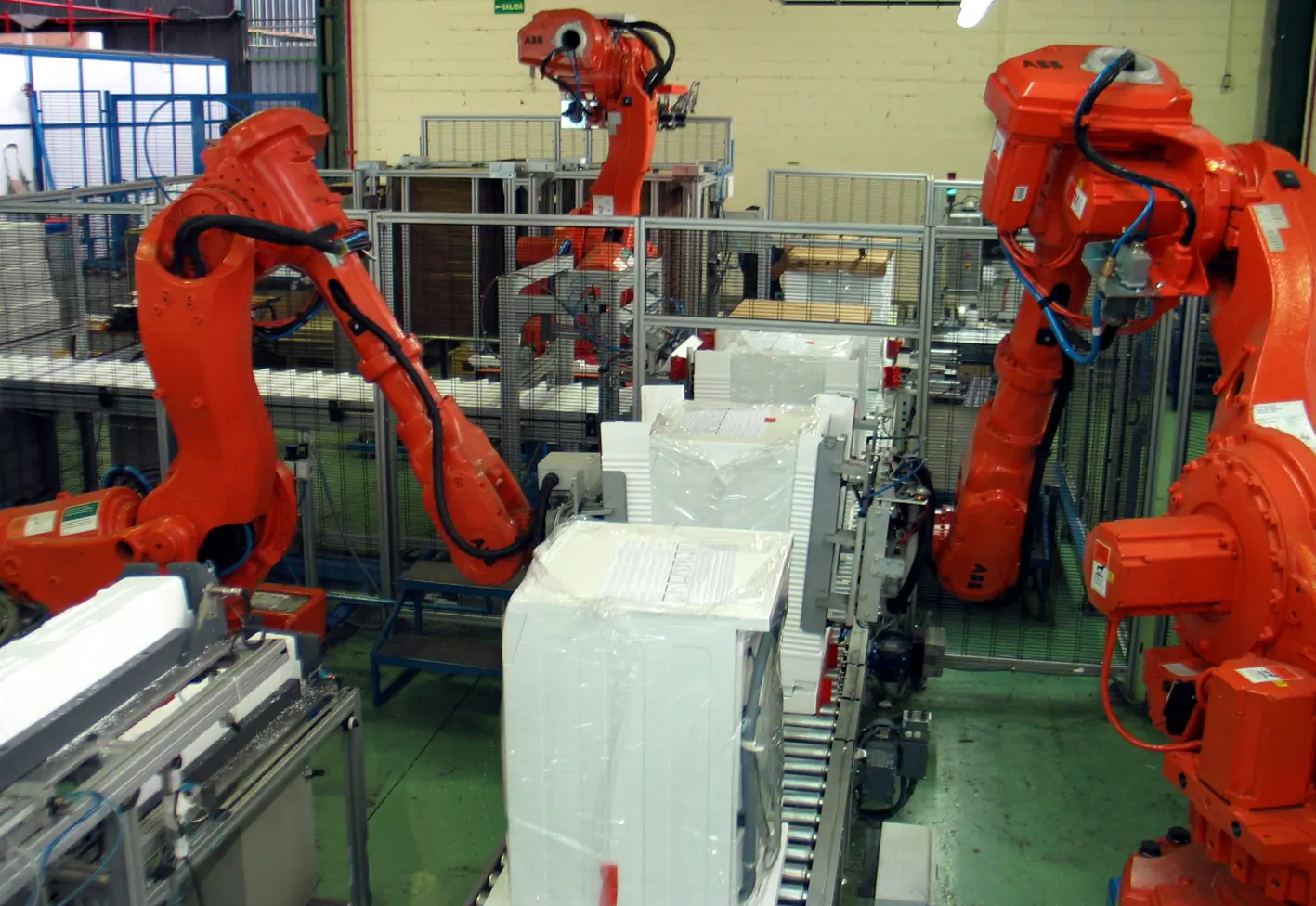 Industrial robots packing products in an automated packing cell